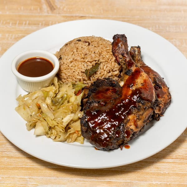Cubana Grille's jerk chicken with rice and peas, steamed cabbage, and a side of sauce.